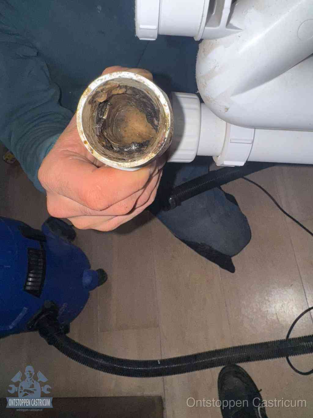 Een losgekoppeld afvoerbuisstuk dat van binnen volledig is dichtgeslibd, het gevolg van een verstopping te lang laten zitten in Castricum