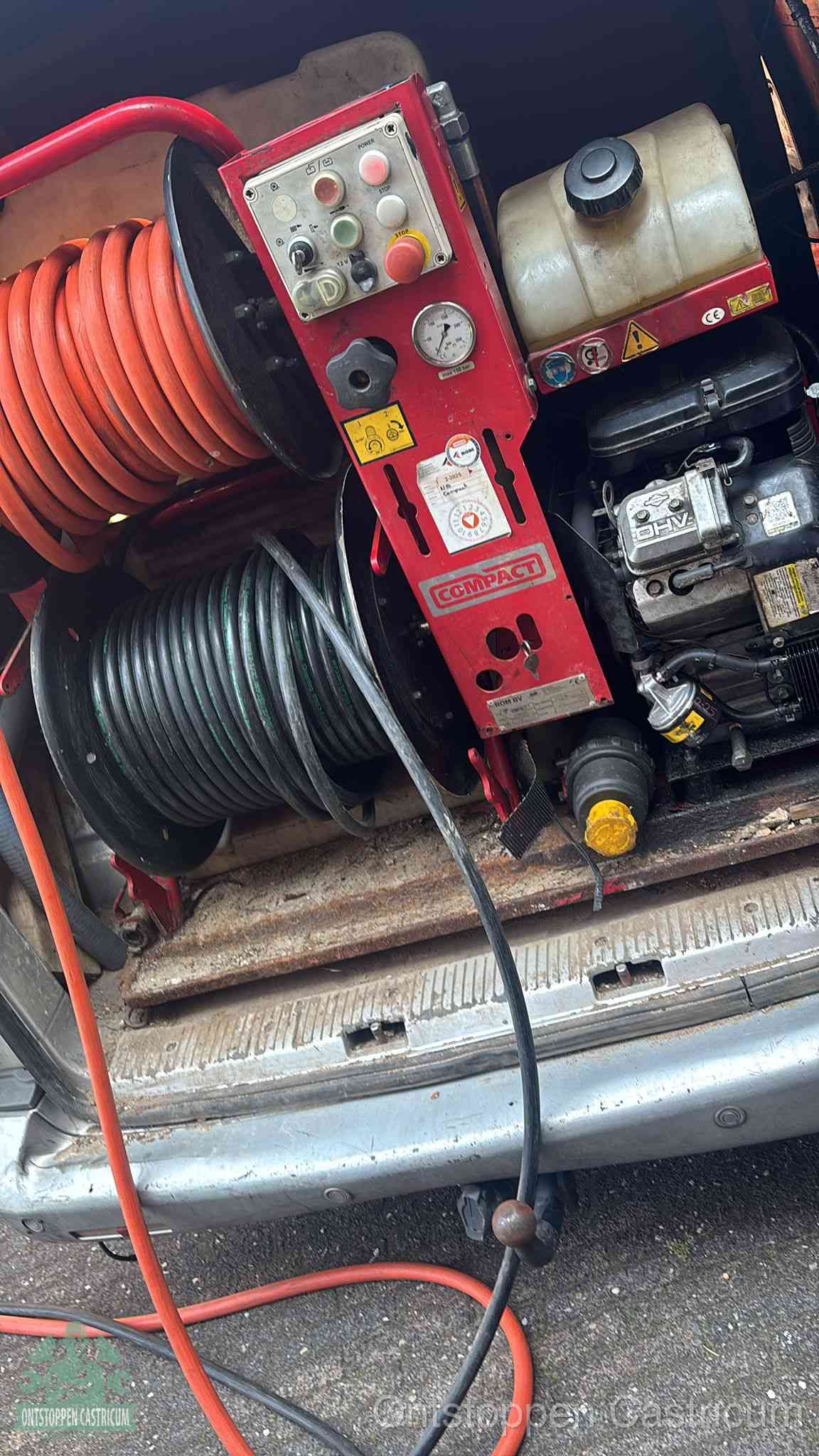 Een rood hogedruk-rioolreinigingstoestel in de laadbak van de bedrijfsbus, apparatuur voor een hardnekkige afvoerverstopping in Castricum