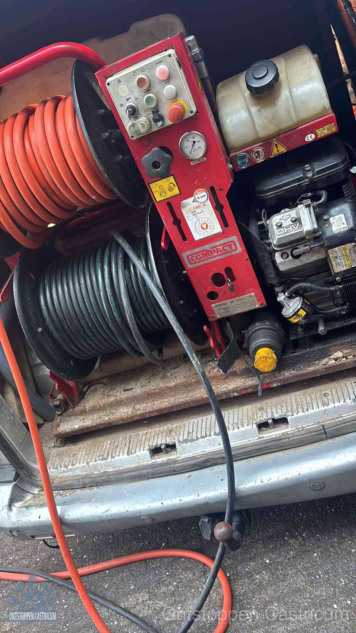 Een rood hogedruk-rioolreinigingstoestel met slangen in de laadbak van de bedrijfsbus, apparatuur voor een hardnekkige wc-verstopping in Castricum
