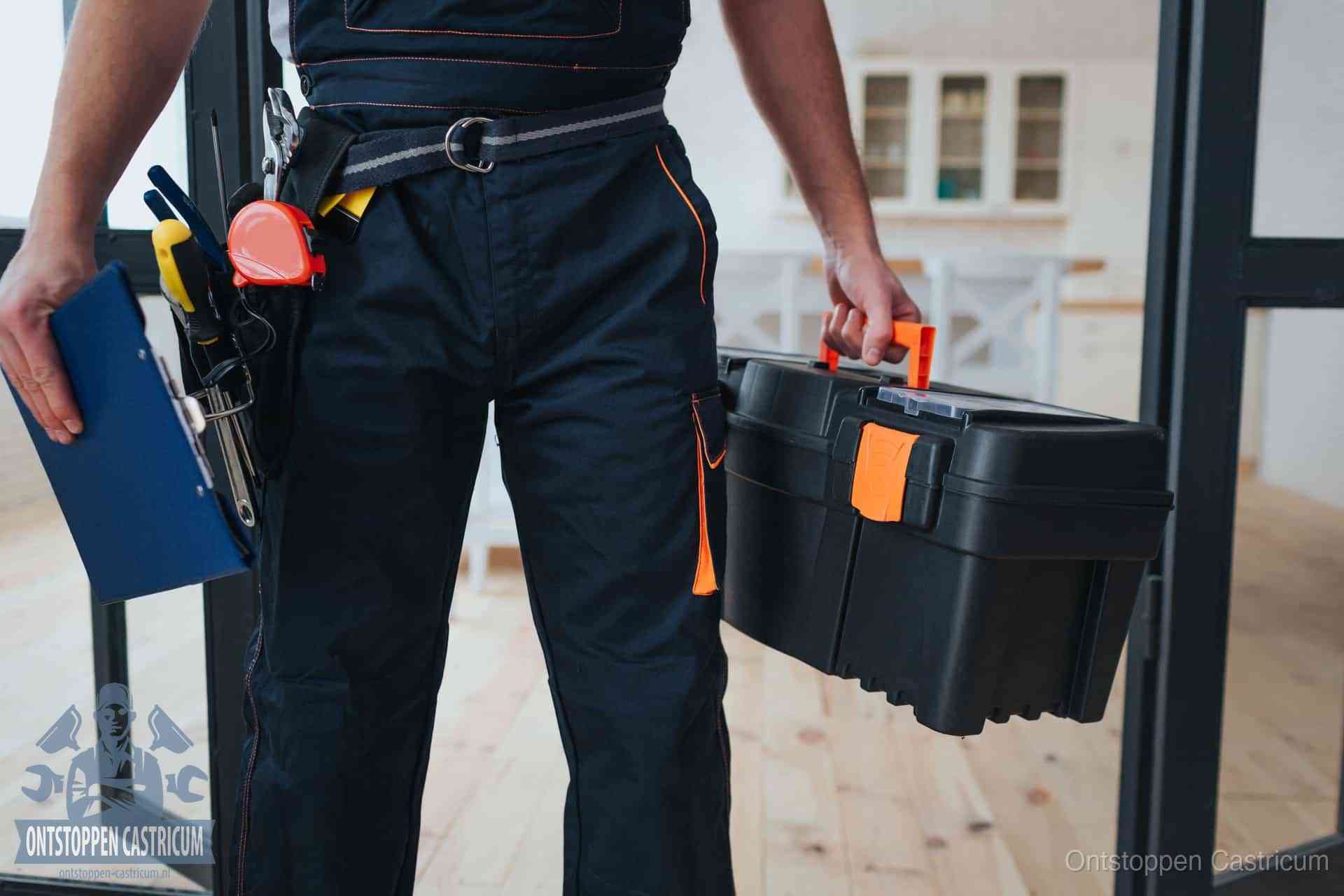 Een monteur met gereedschapsriem en klembord in een keuken, klaar om een transparante prijs voor het gootsteen ontstoppen in Castricum te geven