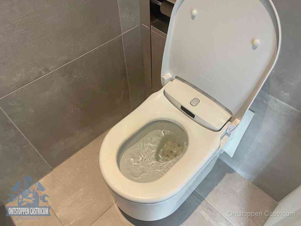 Een toiletpot vol troebel water met drijvend papier en restanten, de meest voorkomende oorzaak van een verstopte wc in Castricum