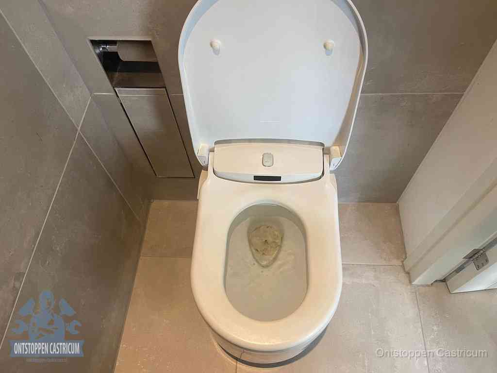 Een wit hangtoilet waarin een prop wc-papier op het water blijft drijven, een duidelijk signaal van een verstopte wc in Castricum