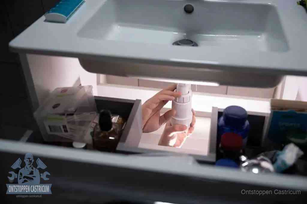 Een pompfles met zeep boven een wastafel in de toiletruimte, de warm water en afwasmiddel-methode om de wc te ontstoppen in Castricum